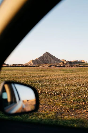 Une vue panoramique sur les montagnes désertiques des Bardenas Reales, admirée depuis la fenêtre d'une voiture